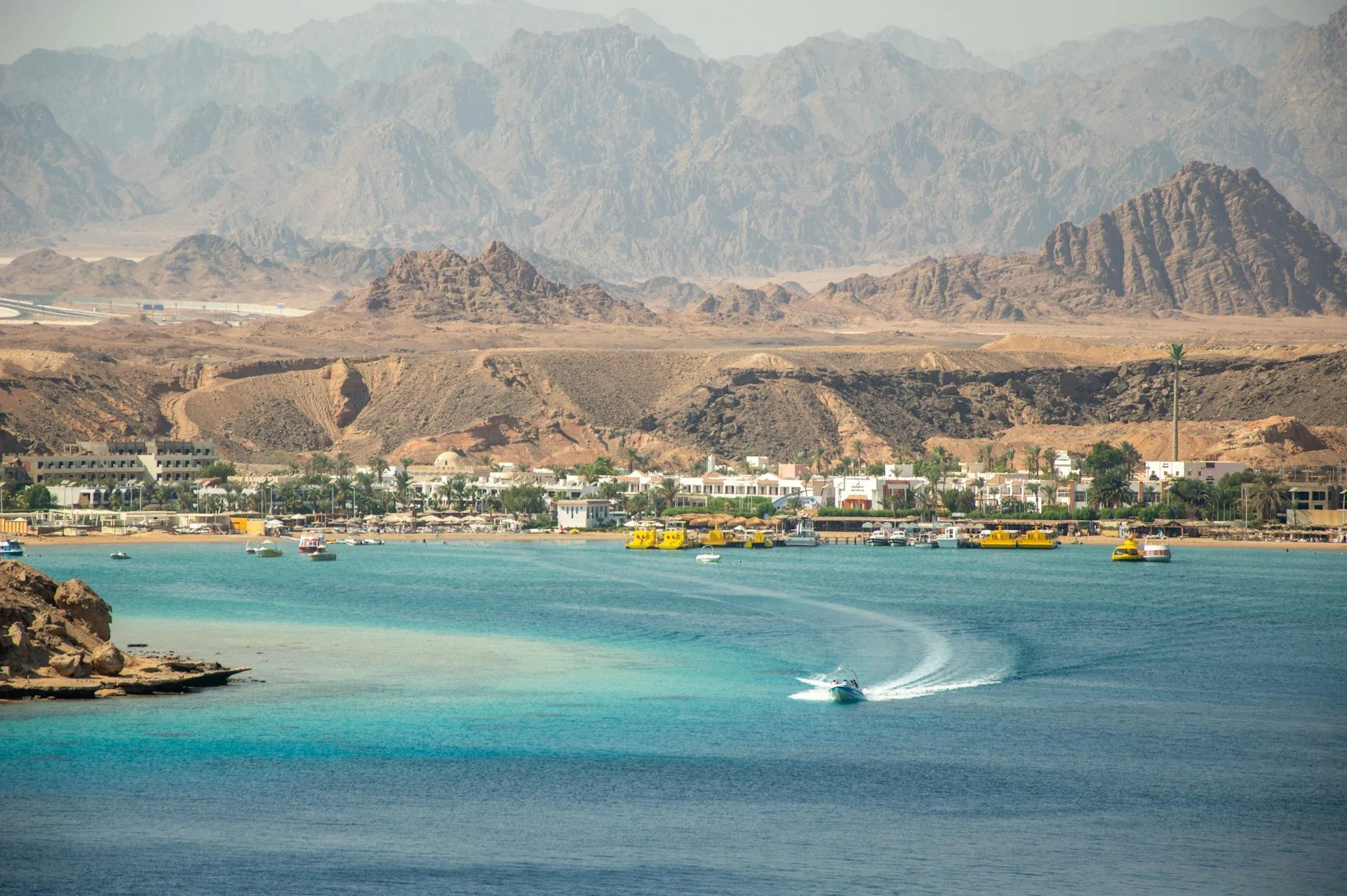 Best Time to Dive the Red Sea (Month-by-Month Guide) 1 Aerial view of Sharm El Sheikh coastline with turquoise water and boats enjoying water activities.